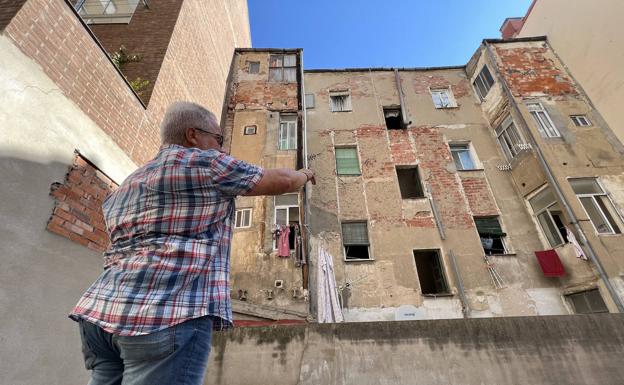 Pablo Gonzalo muestra el estado de la fachada trasera del edificio desde el que se filtran las aguas fecales.