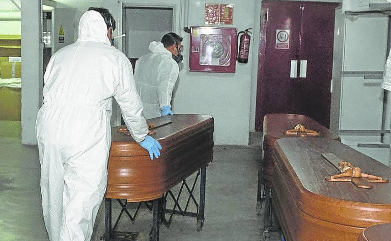 Servicios funerarios trasladan unos féretros durante la pandemia. 