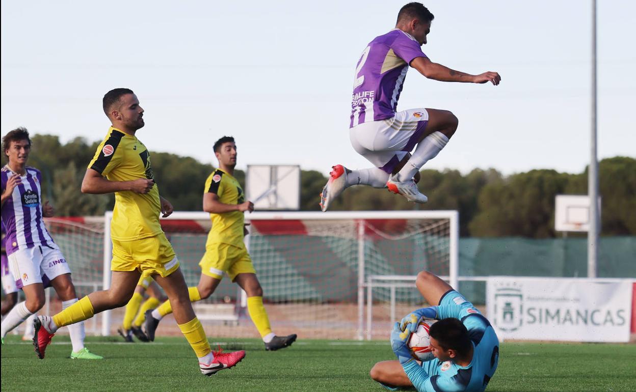 El meta Cristian bloca el balón ante la llegada de un jugador del Promesas. 