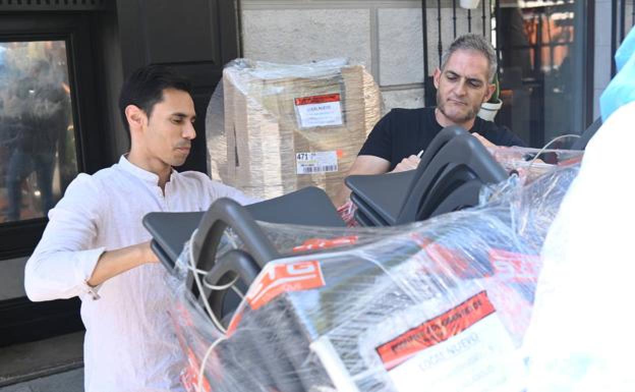 Javier Hernández y Nacho López, dueños del bar, sacan del embalaje las sillas que poblarán la terraza.