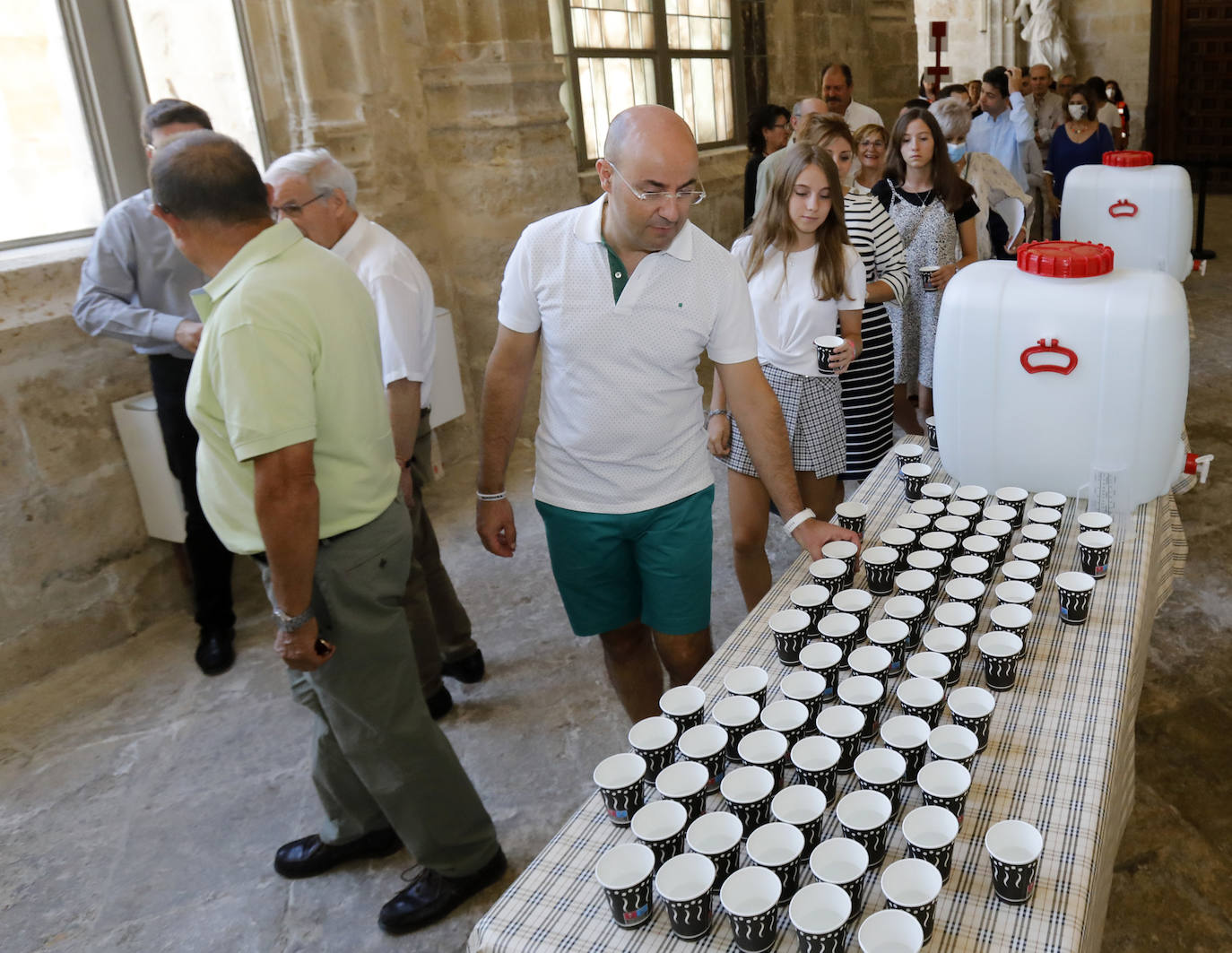 Centenares de fieles acuden a la Catedral para recoger su vaso de agua del grifo bendecida. 