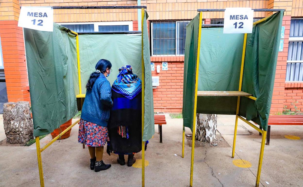 Dos mujeres seleccionan la papeleta para votar en el referéndum de la nueva constitución de Chile.