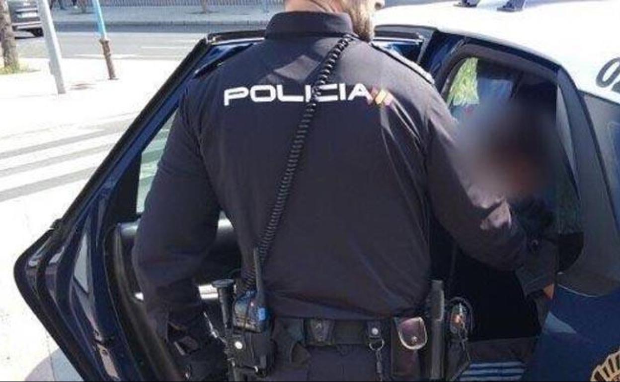 Imagen de archivo de un agente que introduce a un detenido en un vehículo policial. 