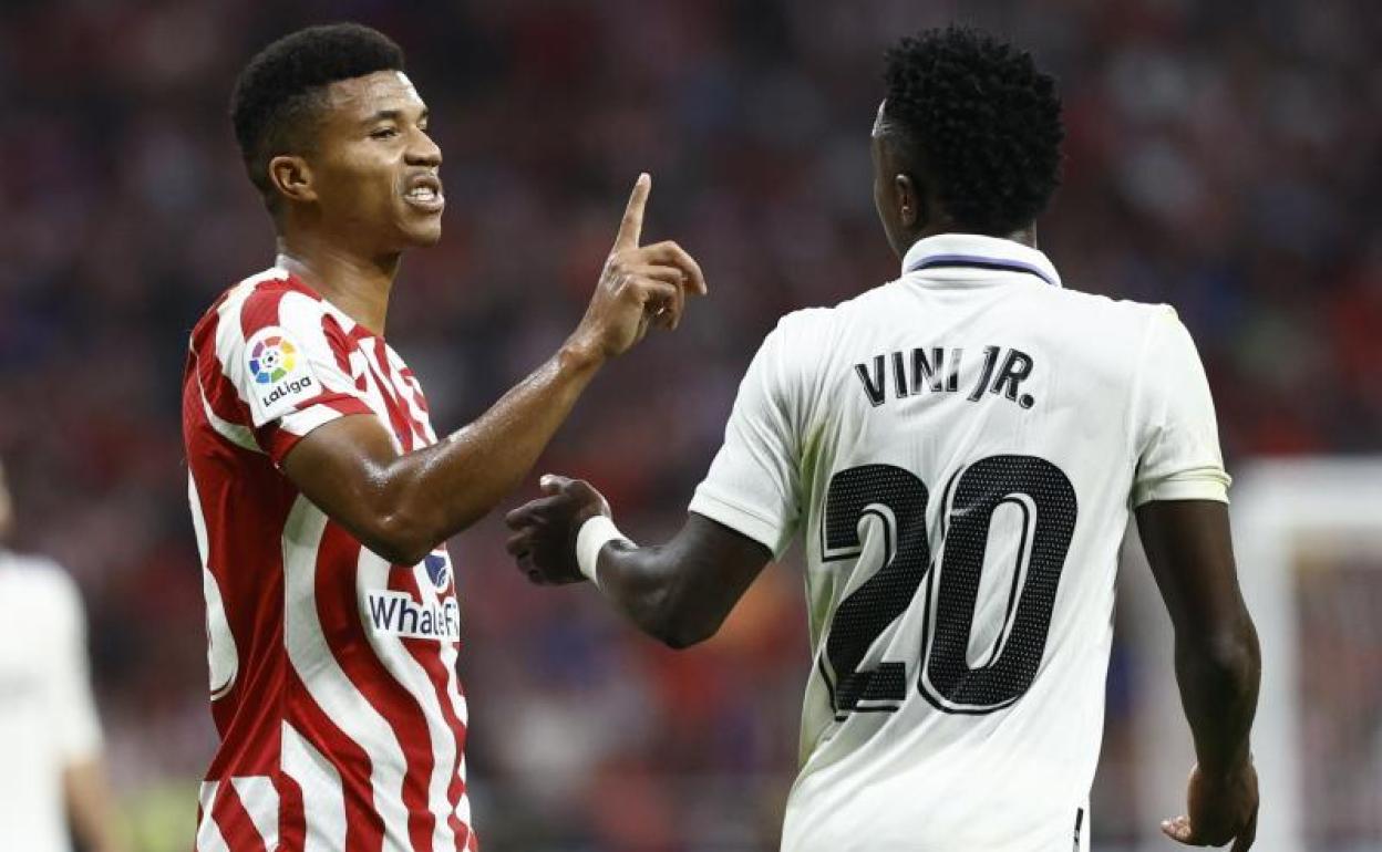 Vinicius (d) y Reinildo discuten durante el derbi madrileño en el Metropolitano. 