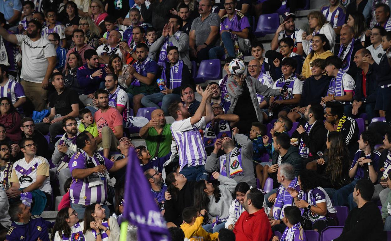 Un aficionado recoge un balón despejado a la grada durante el partido ante el Cádiz. 