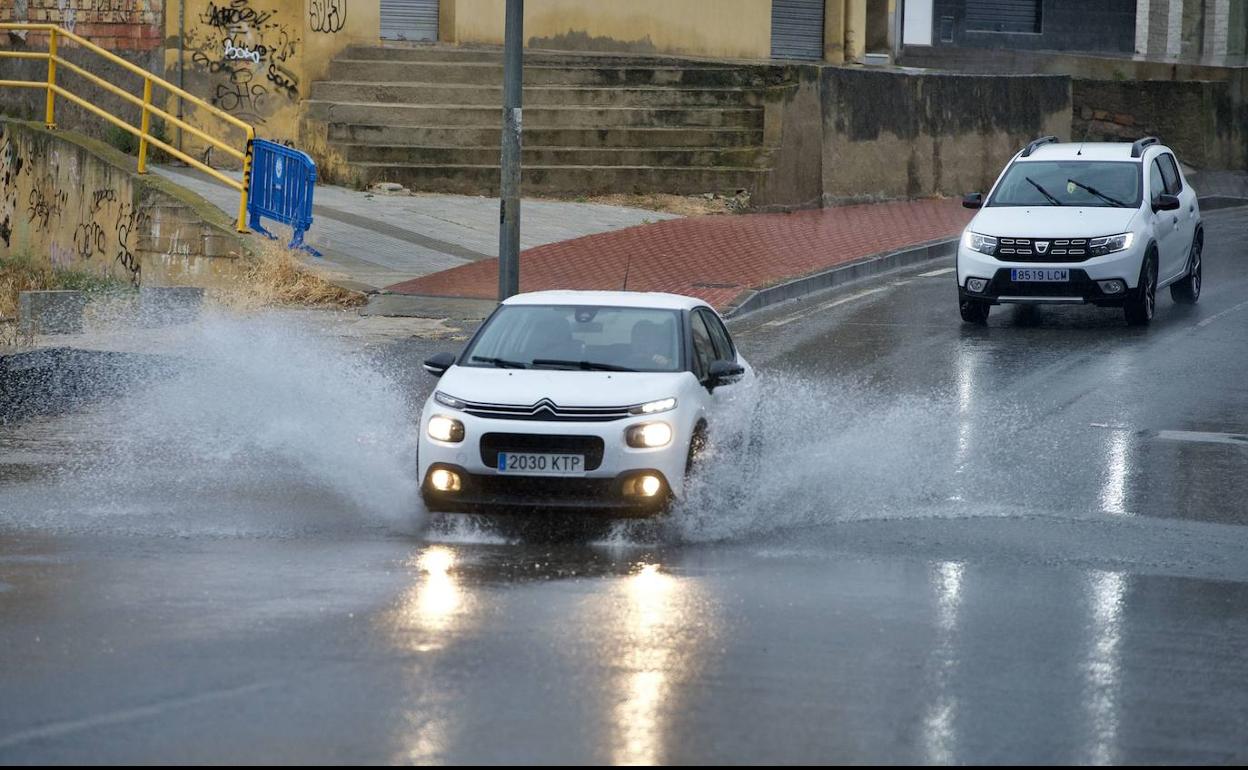 Unos vehículos conducen en un día lluvioso 