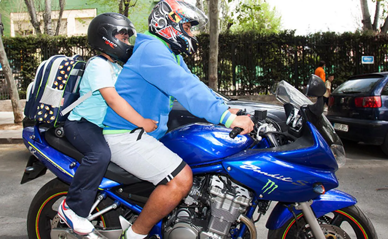 Un menor viaja en una moto acompañado de un adulto. 