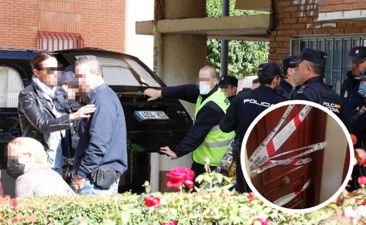 Los servicios funerarios introducen el cadáver de la joven en el coche en medio de una fuerte presencia policial. En el círculo, puerta del domicilio precintada.