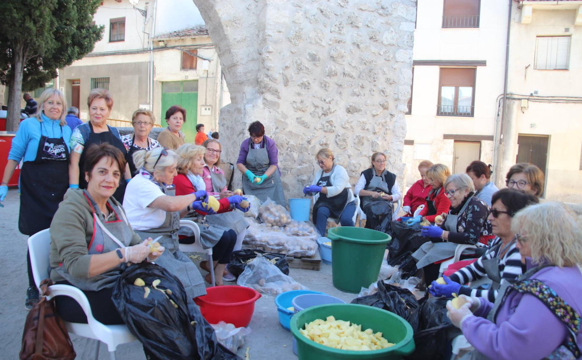 Mujeres pelan patatas para el guiso.