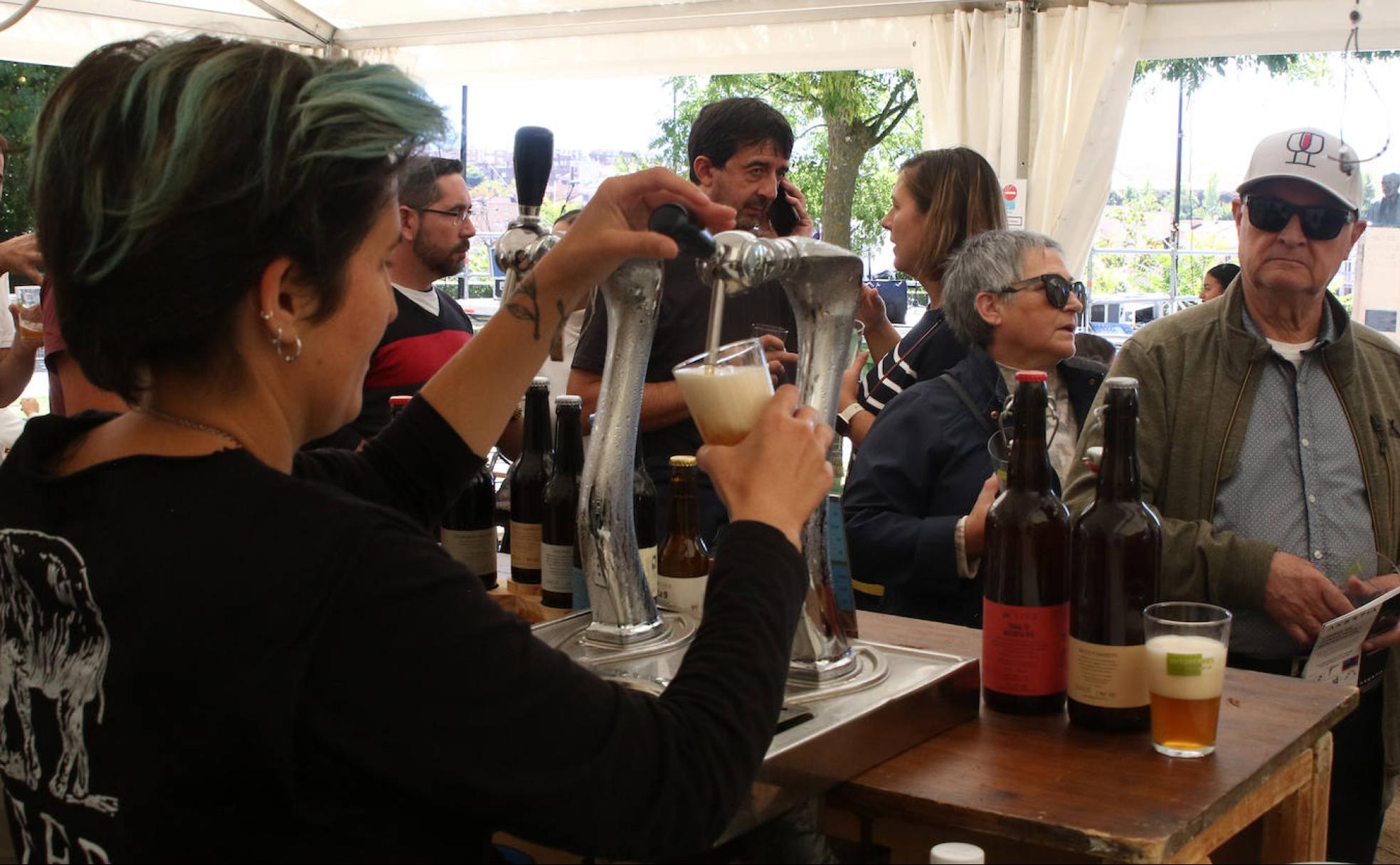 Una mujer tira un caña de cerveza en una de las carpas de la feria, este sábado, en el paseo del Salón. 