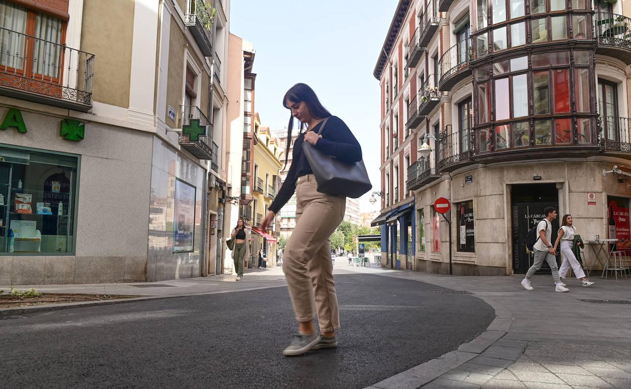 Una joven atraviesa la calle Catedral.