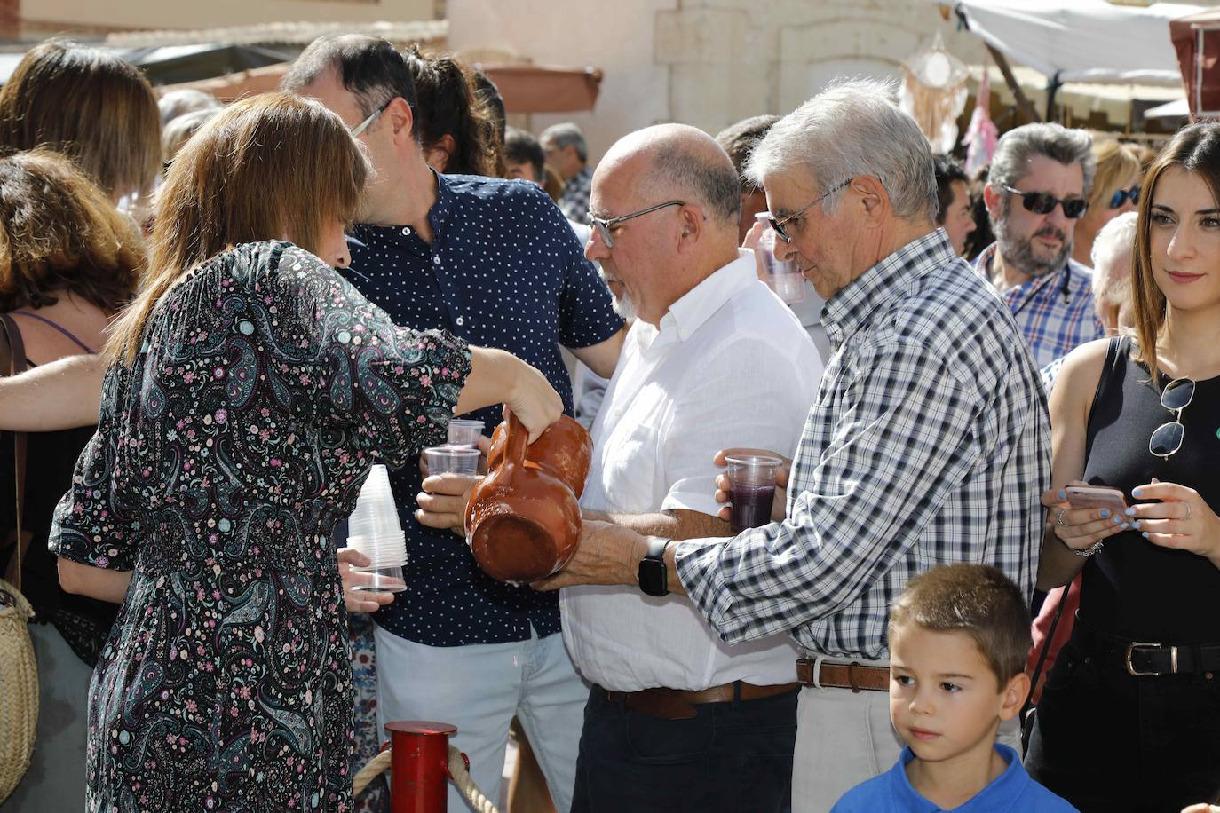 Dos niños pisan la uva para extraer el mosto en la plaza de Quintanilla.