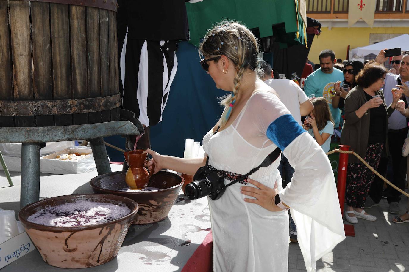 Dos niños pisan la uva para extraer el mosto en la plaza de Quintanilla.