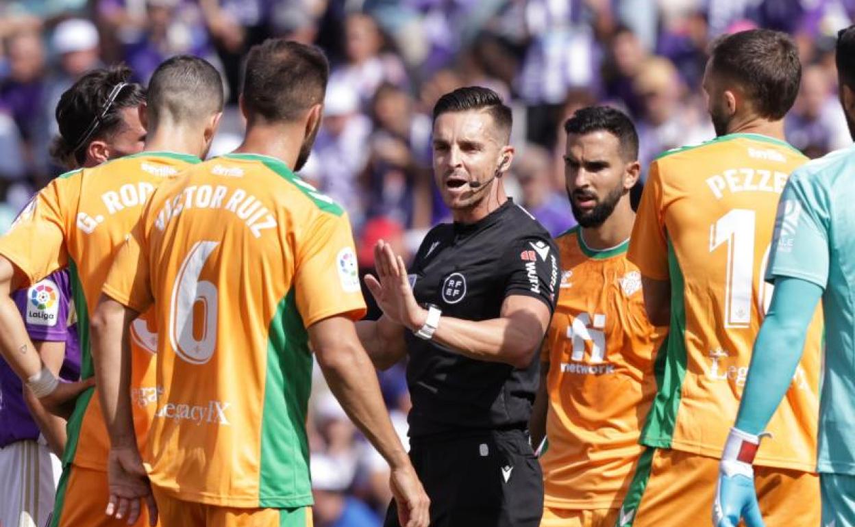 Del Cerro frena a los jugadores béticos tras la expulsión de Pezzella 