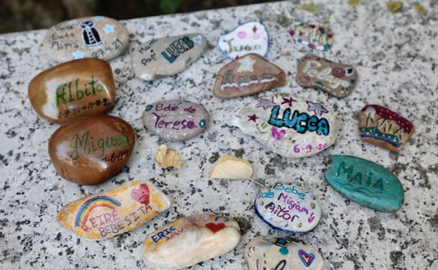 Piedras que recuerdan a los bebés fallecidos pintadas por familiares.