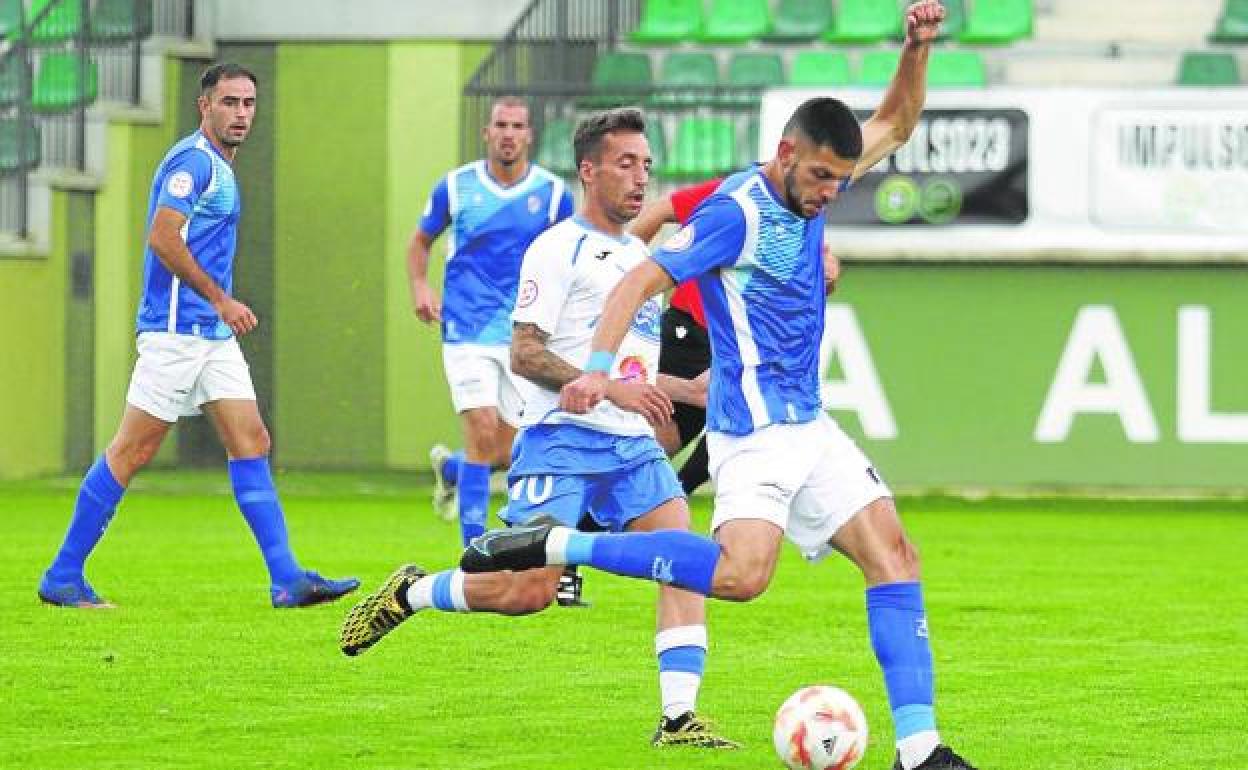 Un jugador del Unami golpea el balón perseguido por un rival del Almazán en el partido de ayer. 