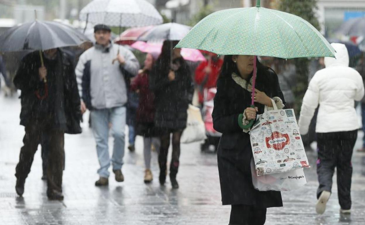 De compras y protegiéndose de la lluvia en la calle Santiago. 