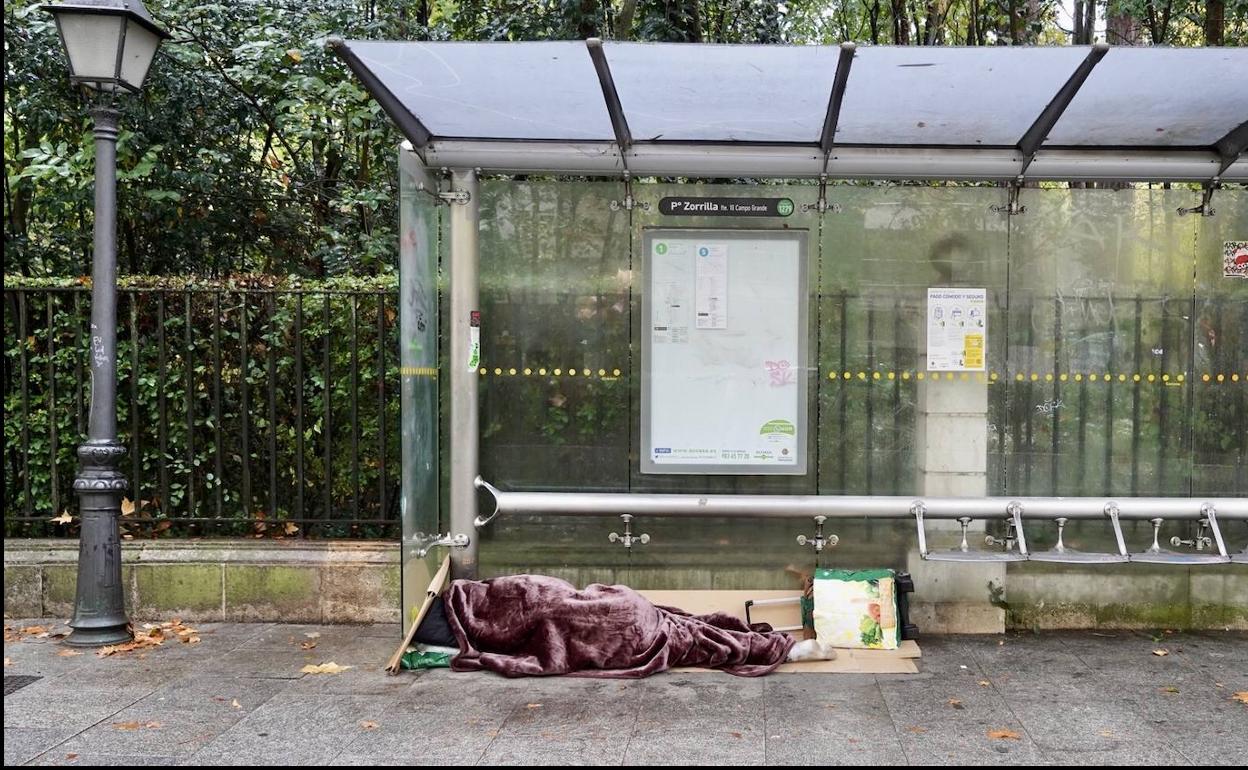 Un indigente duerme bajo una marquesina del Paseo Zorrilla. 