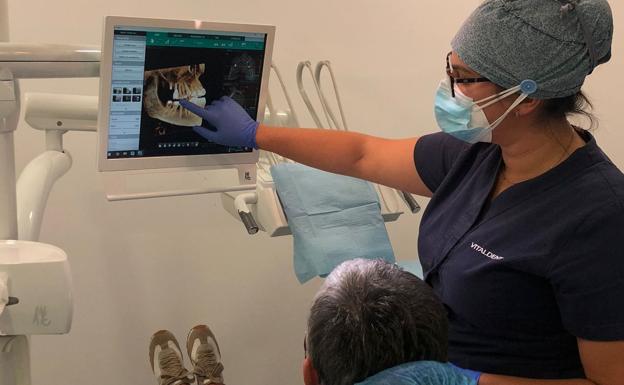 Una doctora explica el TAC DENTAL 3D a una paciente. 