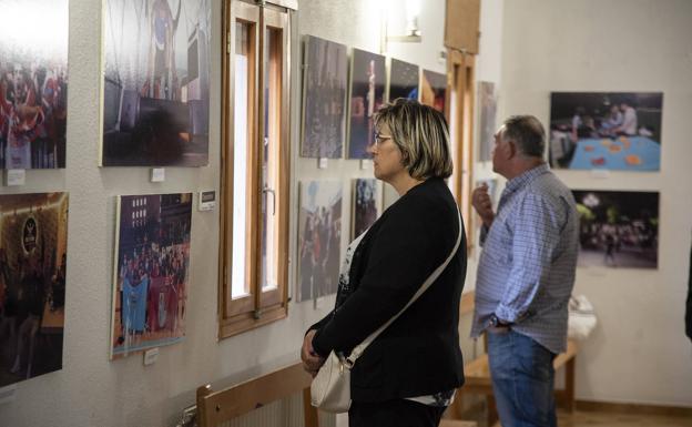 Dos invitados a la exposición contemplan las fotografías.