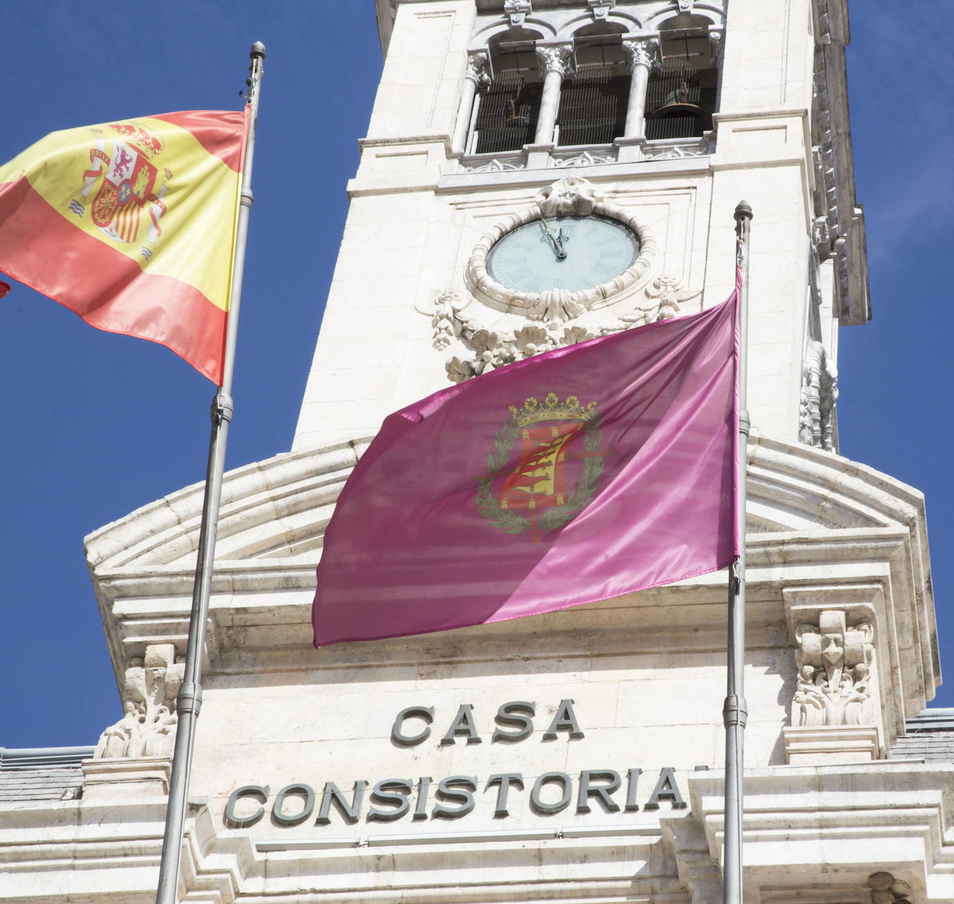 Fachada del Ayuntamiento, donde conviven el escudo en piedra sin la laureada y el oficial con ella de la bandera. 