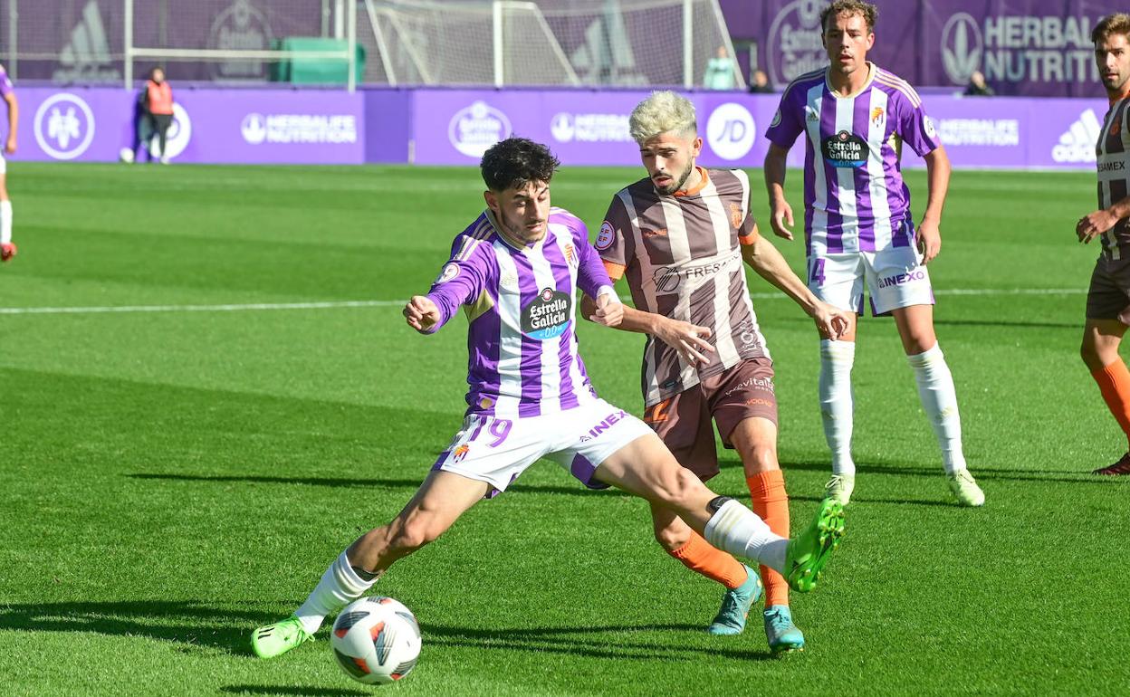 El blanquivioleta Pozo trata de frenar el avance de Isi Ros, jugador del Avilés. 