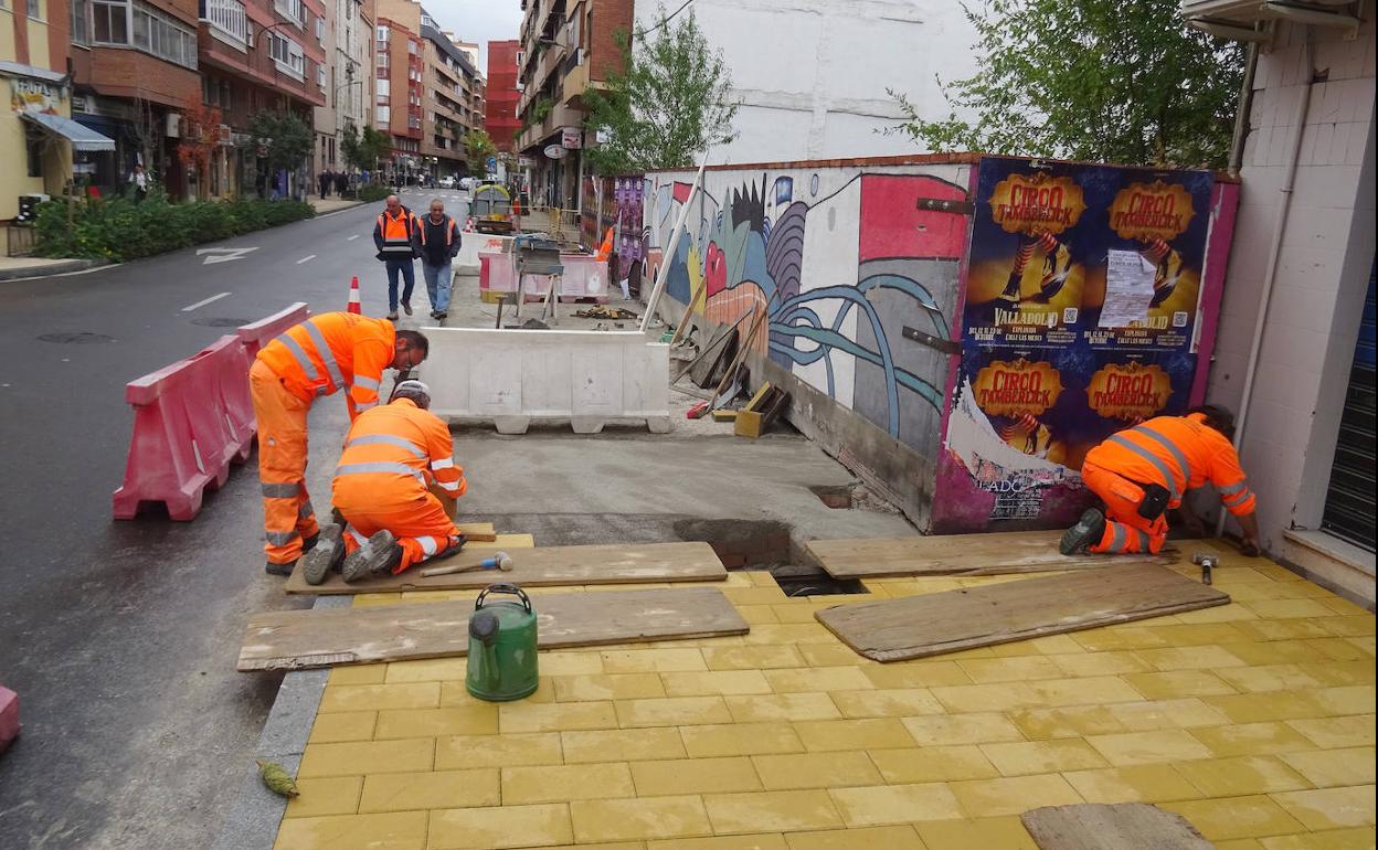 Los operarios colocan los adoquines del tramo ampliado de la acera de la calle Fuente El Sol. 