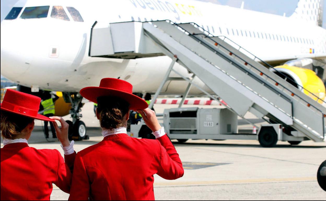 Dos azafatas vestidas de jerezanas delante del avión en el que trabajan.