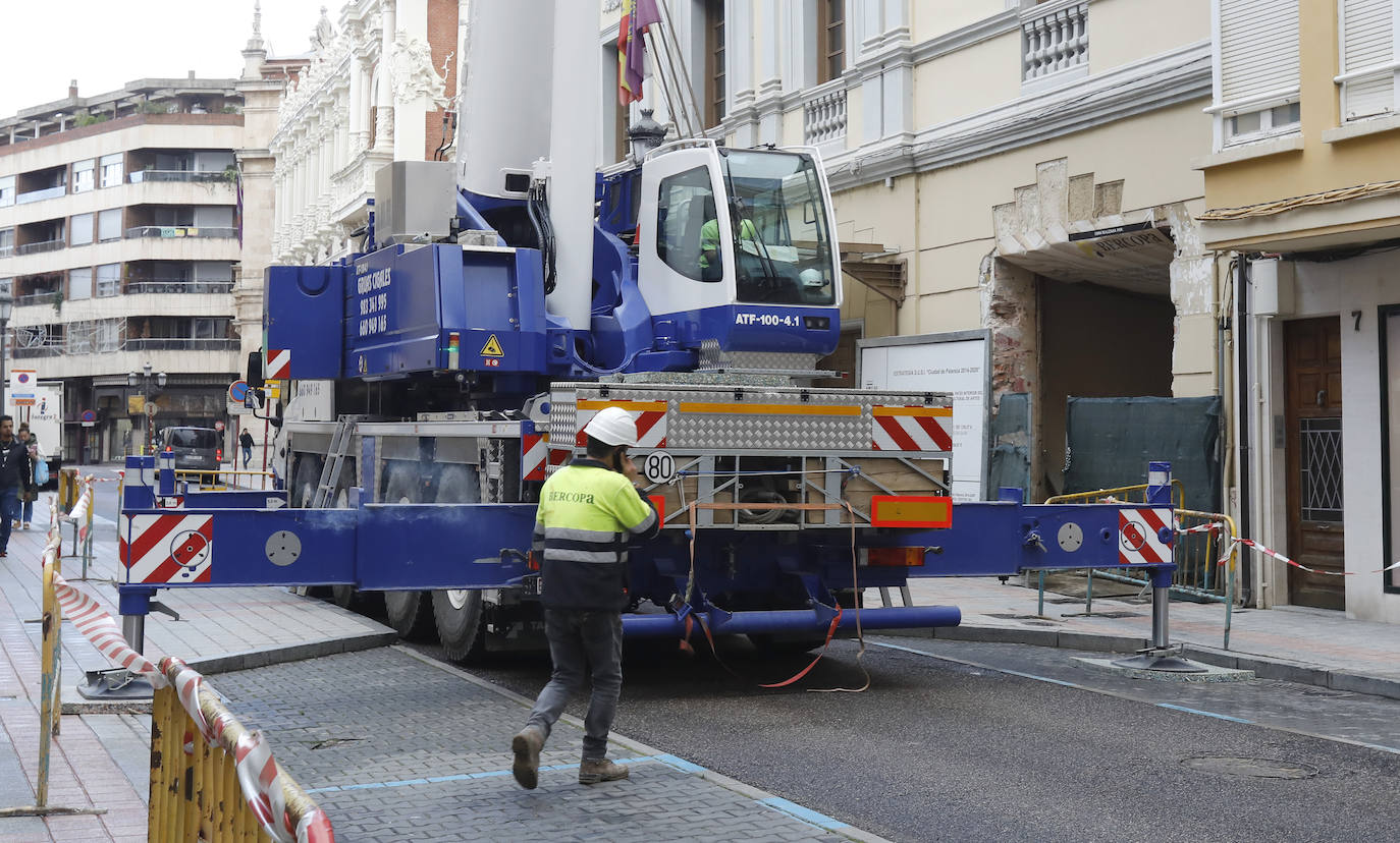 Una grúa de grandes dimensiones trabaja en la calle Burgos para colocar decenas de vigas de madera de tamaño gigante.