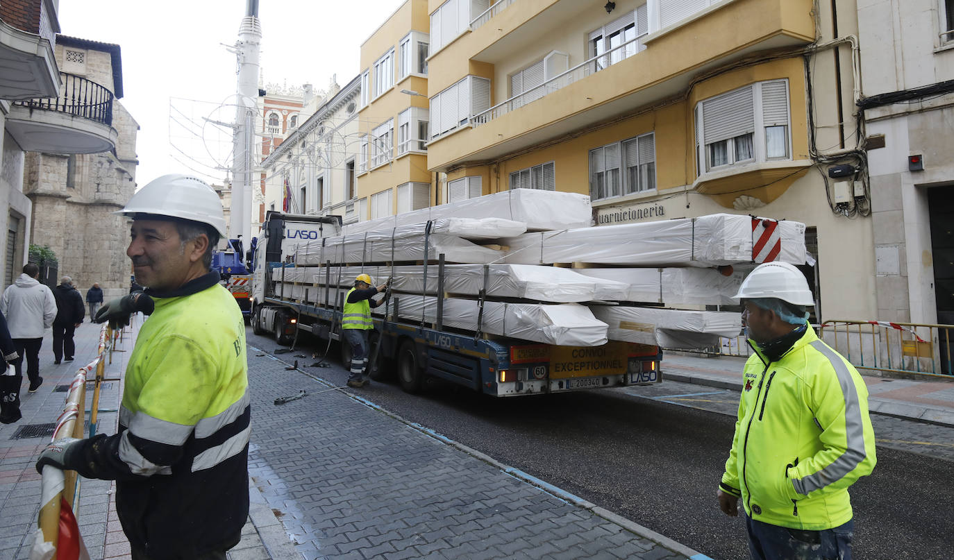 Una grúa de grandes dimensiones trabaja en la calle Burgos para colocar decenas de vigas de madera de tamaño gigante.