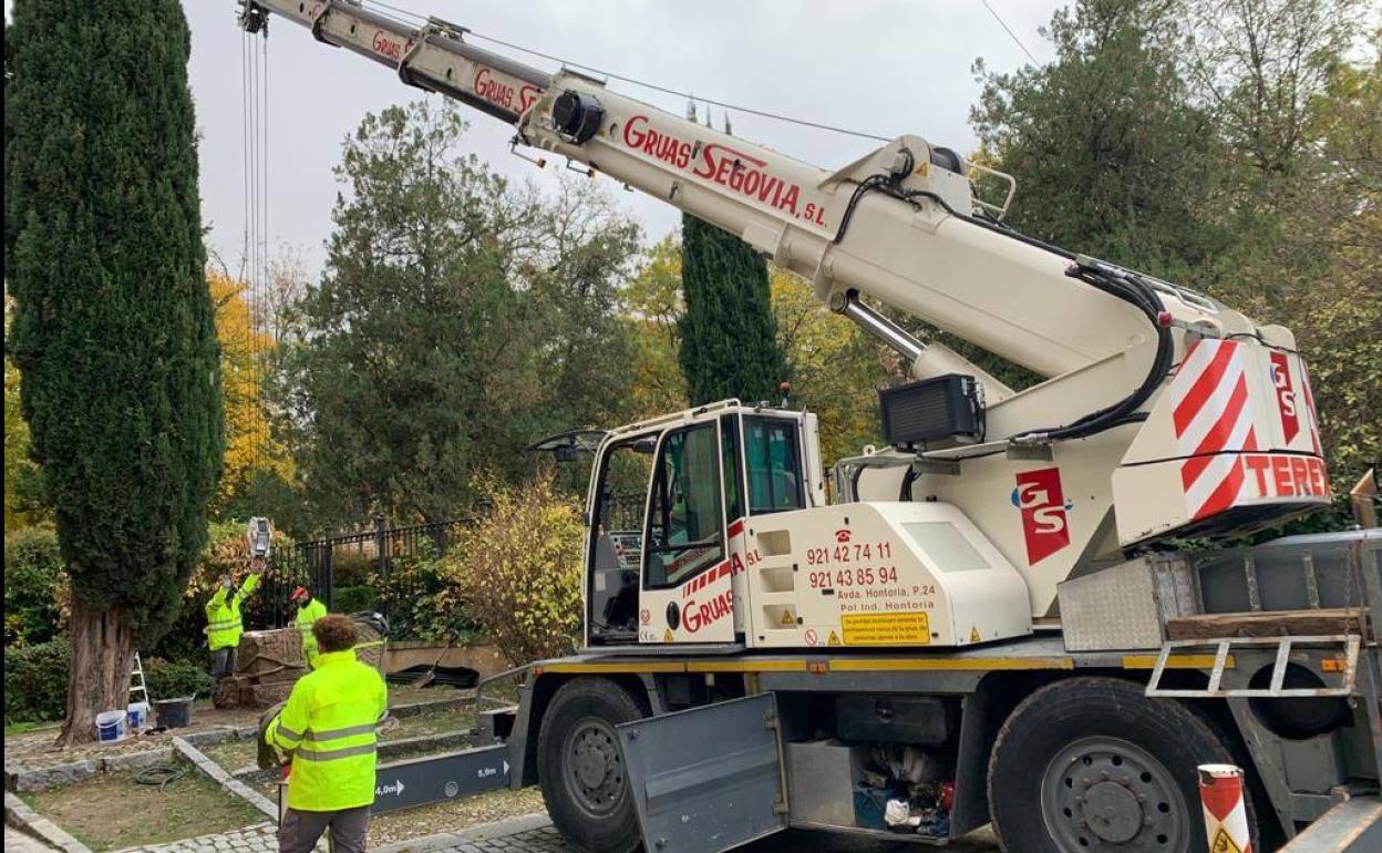 Desmontaje del monumento con varios operarios y una grúa para proceder a su traslado. 