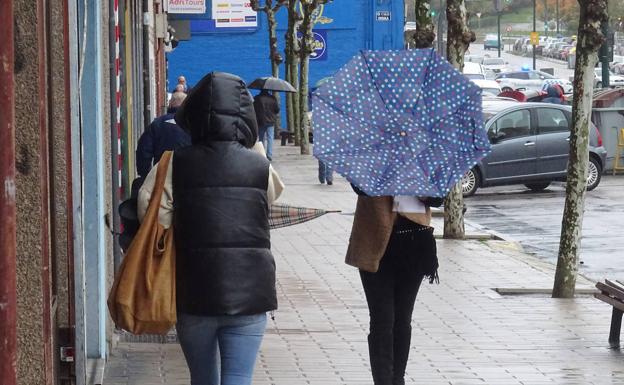 El viento levanta un paraguas a una viandante en el paseo de San Isidro. 