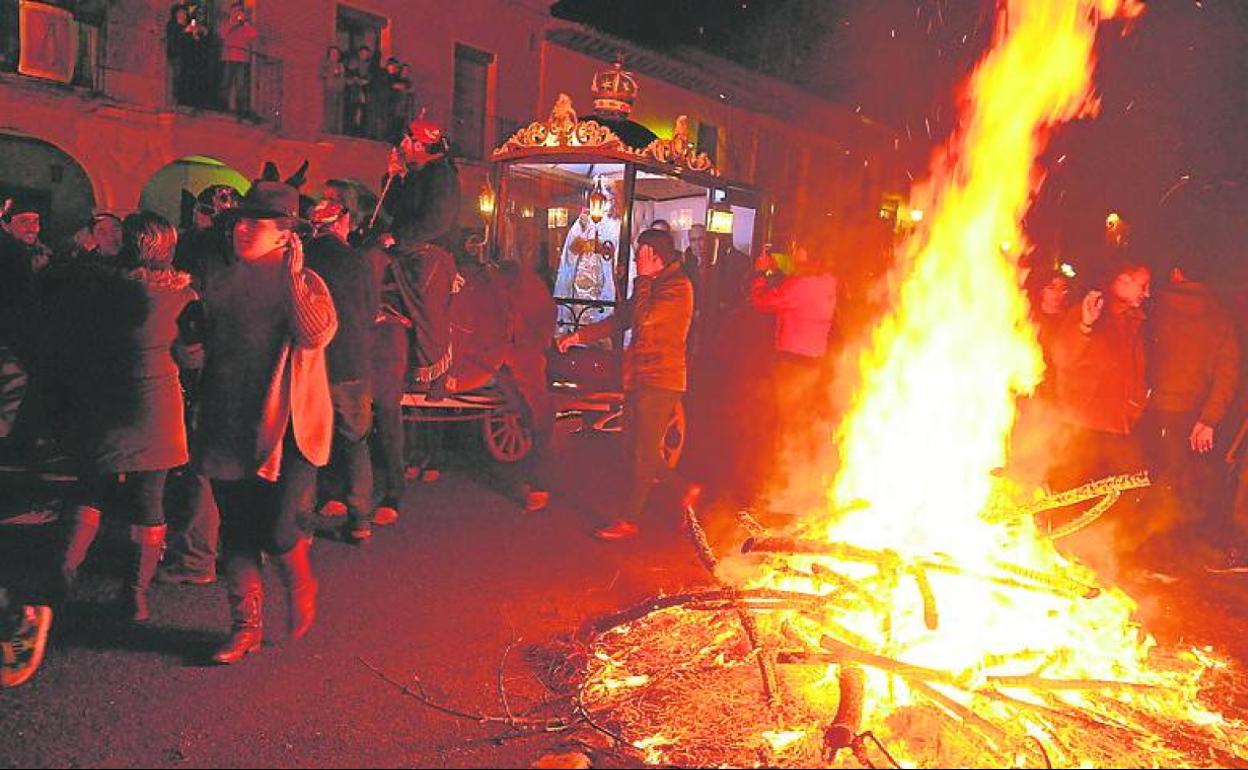 La carroza de la Virgen pasa junto a una de las hogueras.