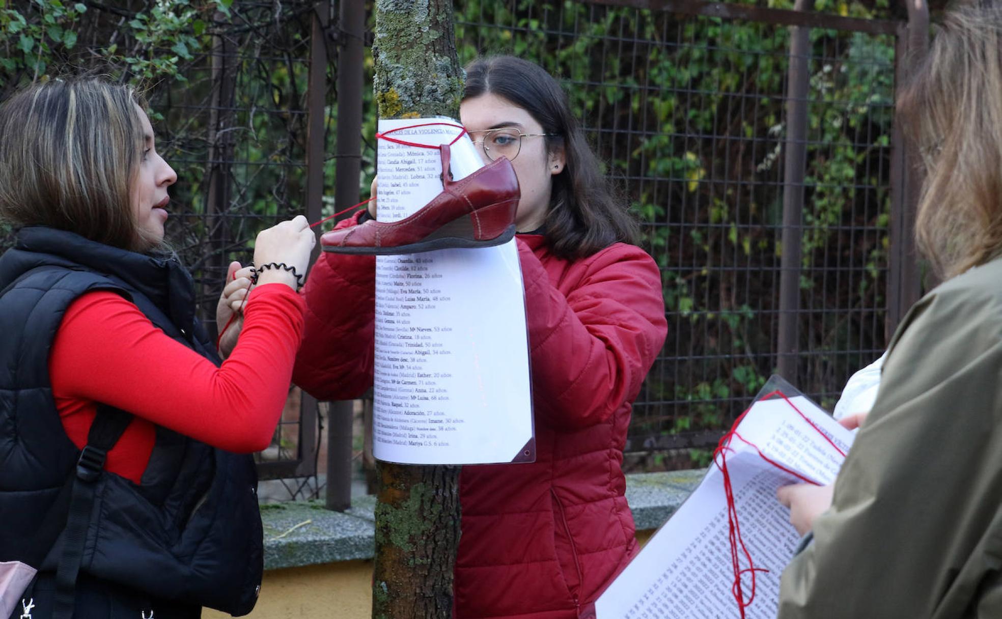 Dos alumnas del Giner de los Ríos colocan en un árbol los nombres de las mujeres asesinadas por sus parejas.