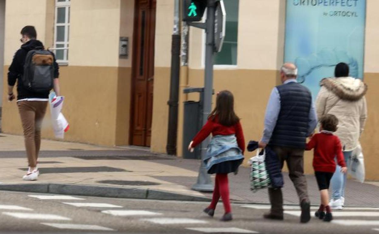 Un abuelo recoge a los nietos a la salida del colegio mientras los padres trabajan. 