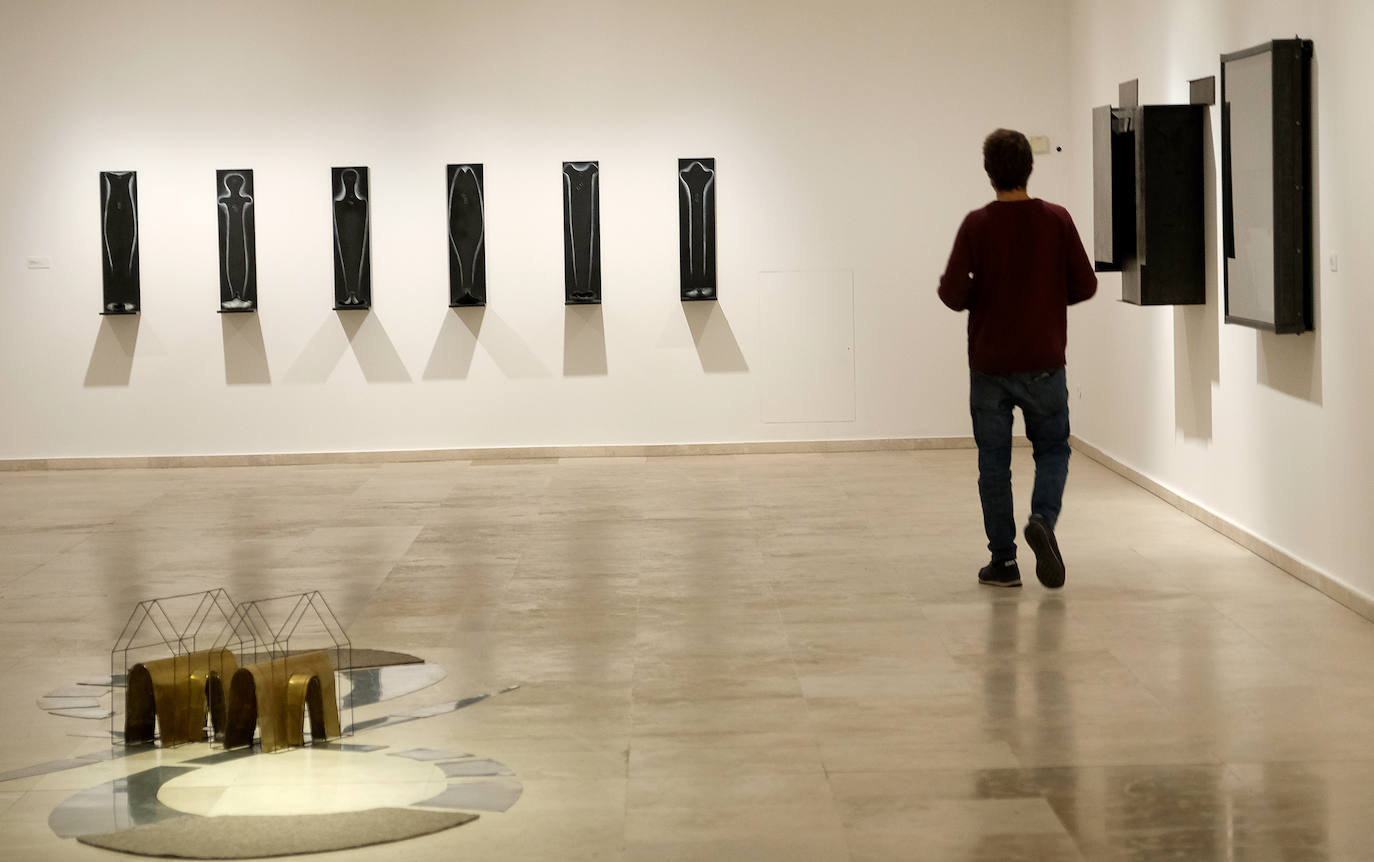 Una mujer observa uno de los cuadros de la exposición.