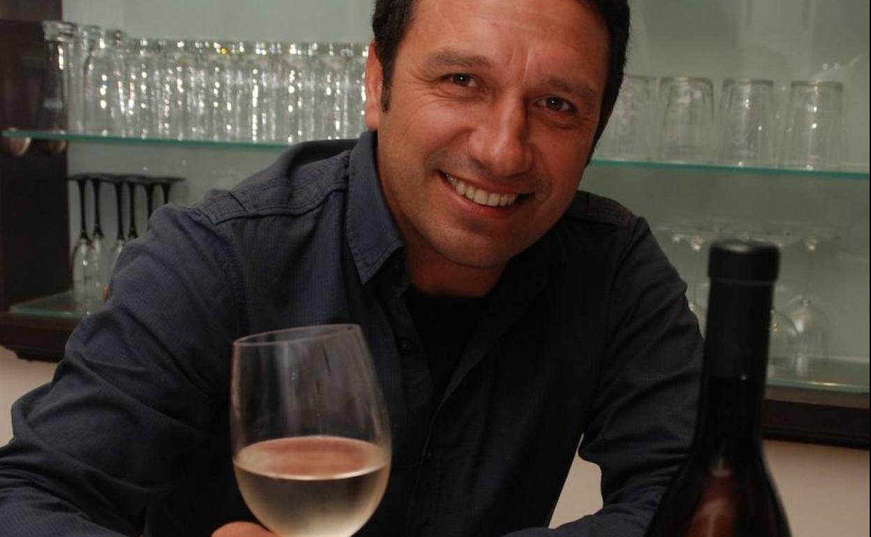 Eusebio Sacristán posa con una copa de vino blanco. 