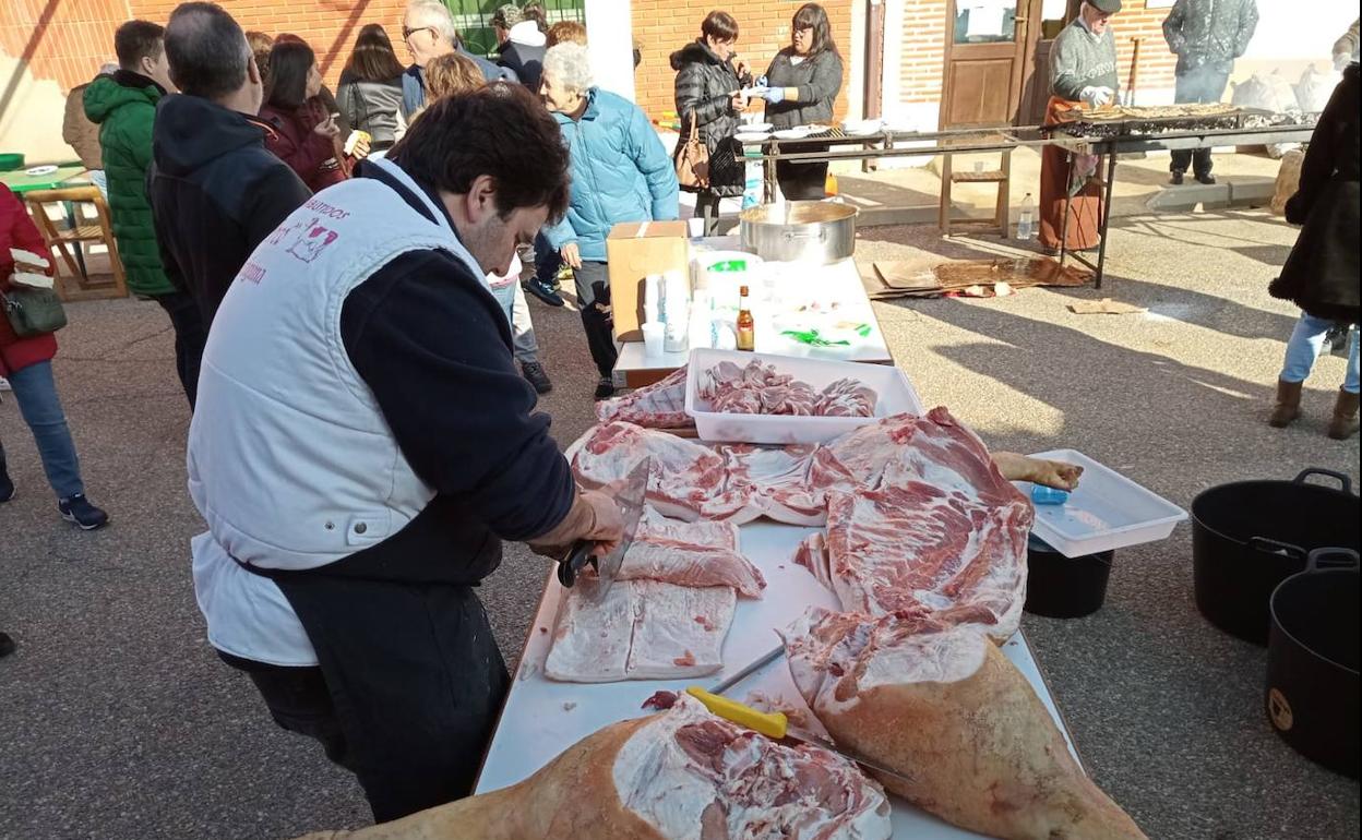 Un carnicero destaza las piezas del cerdo. 