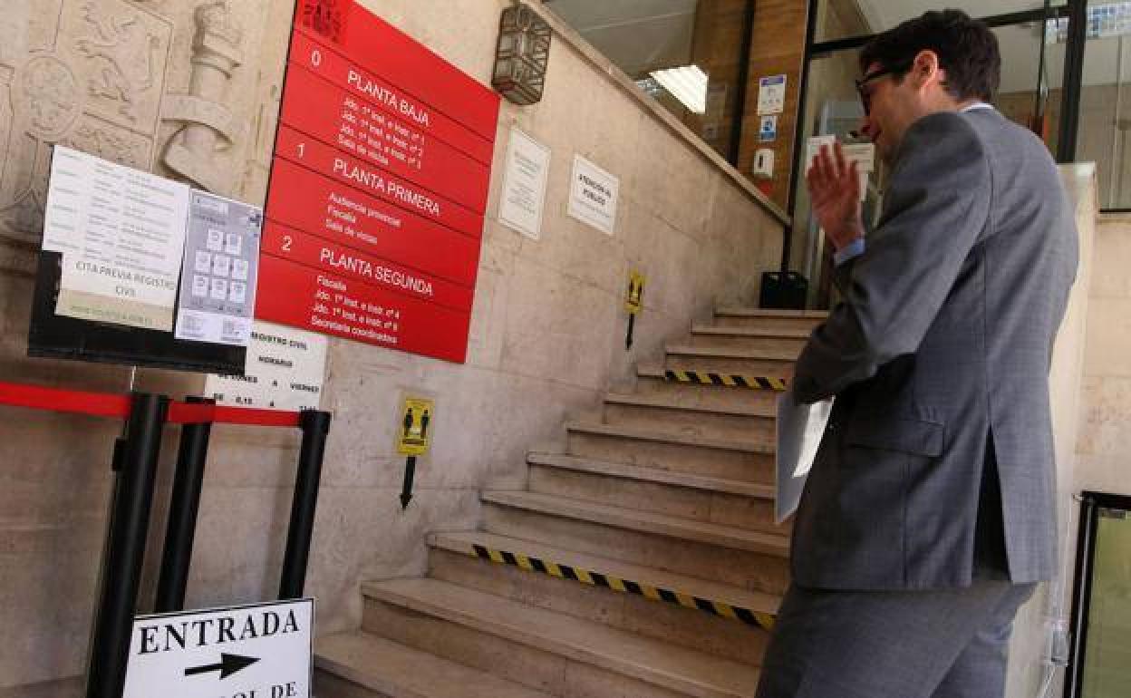 Un abogado consulta el panel informativo a la entrada de la Audiencia Provincial de Segovia.