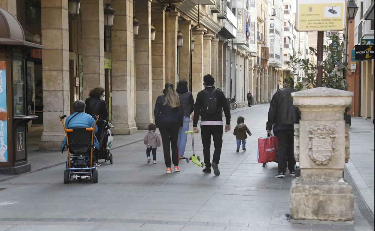 Varias personas, de todas las edades, caminan por la Calle Mayor, junto a los Cuatro Cantones. 