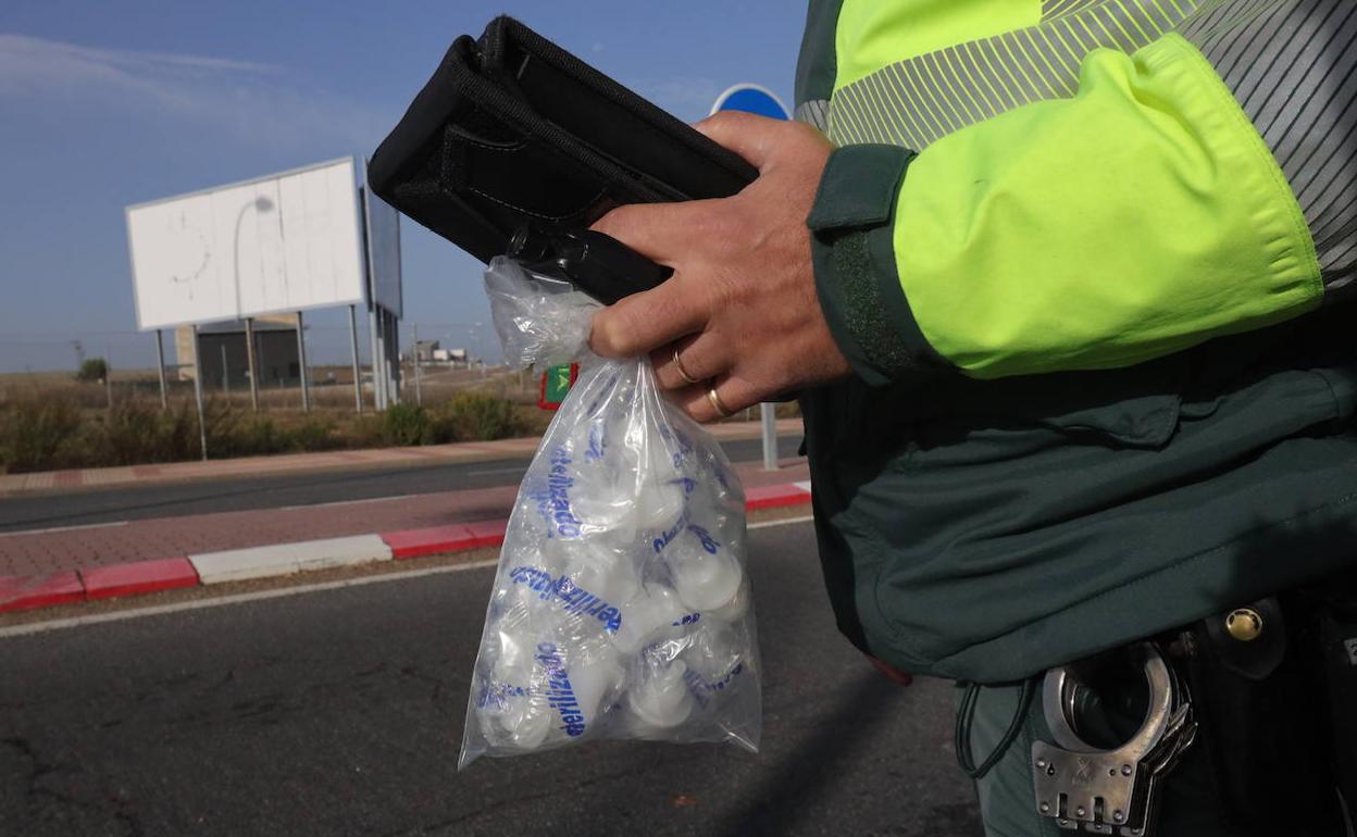 Agente de Tráfico con una bolsa de boquillas en un control de alcohol y drogas.