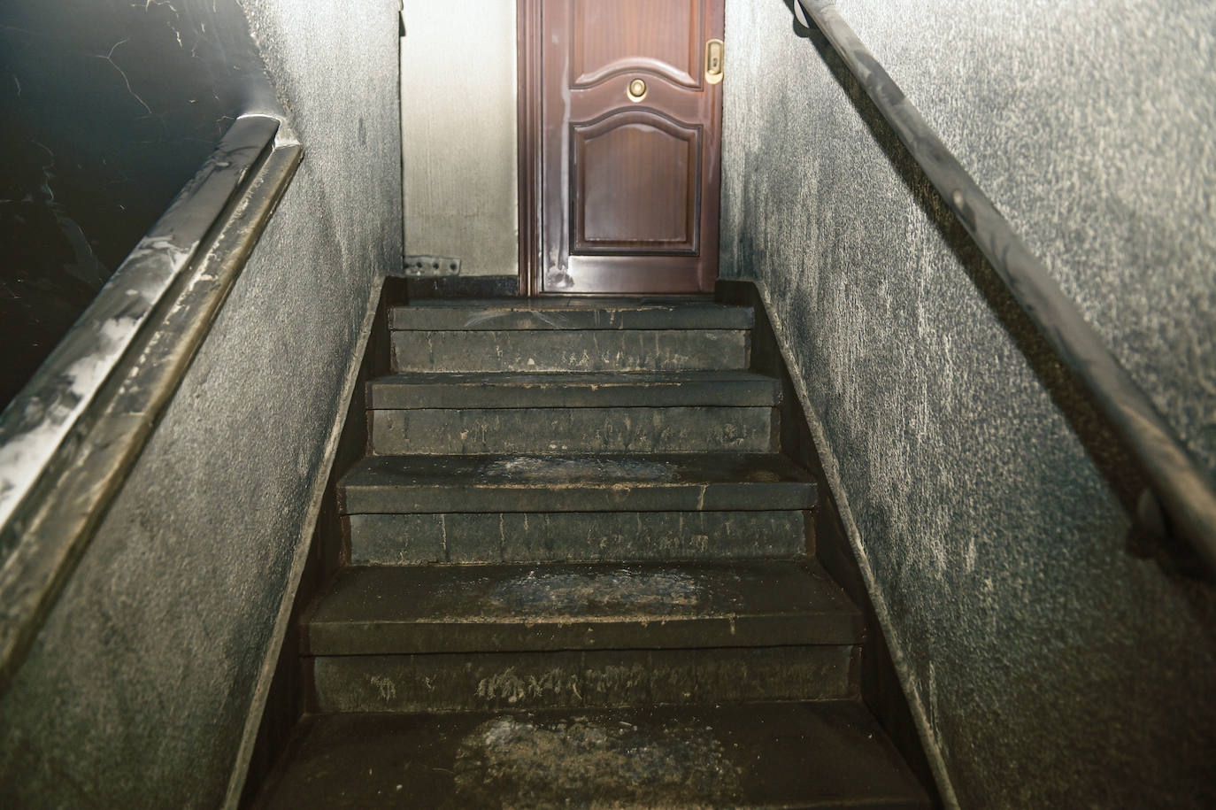 Puerta y portal de la vivienda donde se produjo el incendio.