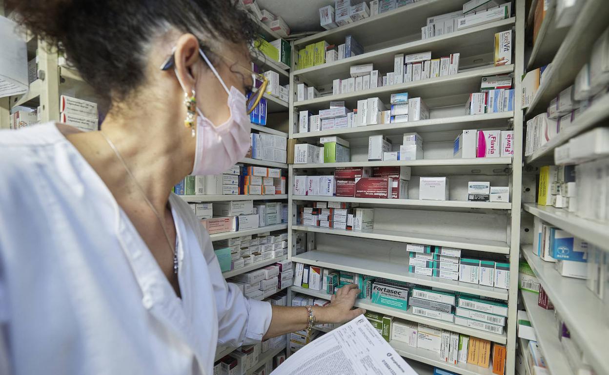 Una farmacéutica busca un medicamento.