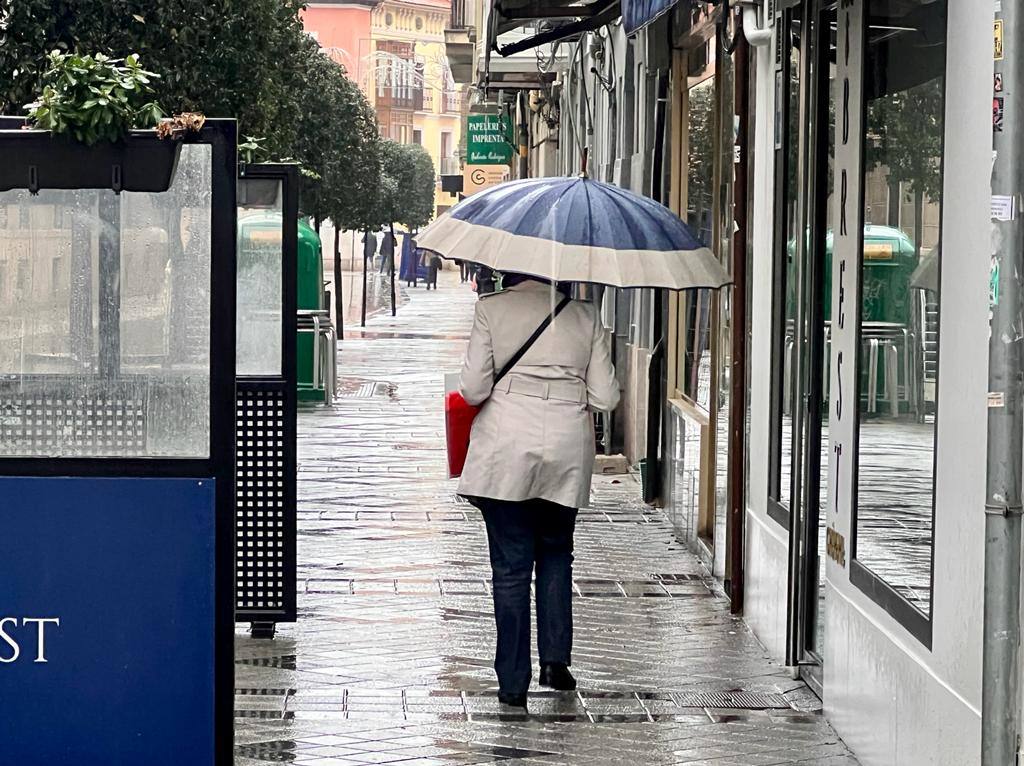 Una persona salta una balsa de agua en una calle de Valladolid.