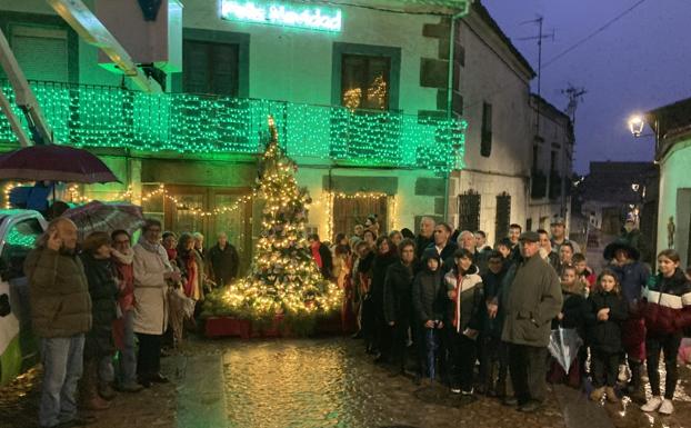 Las integrantes de la asociación y otros vecinos del pueblo durante el encendido del árbol. 