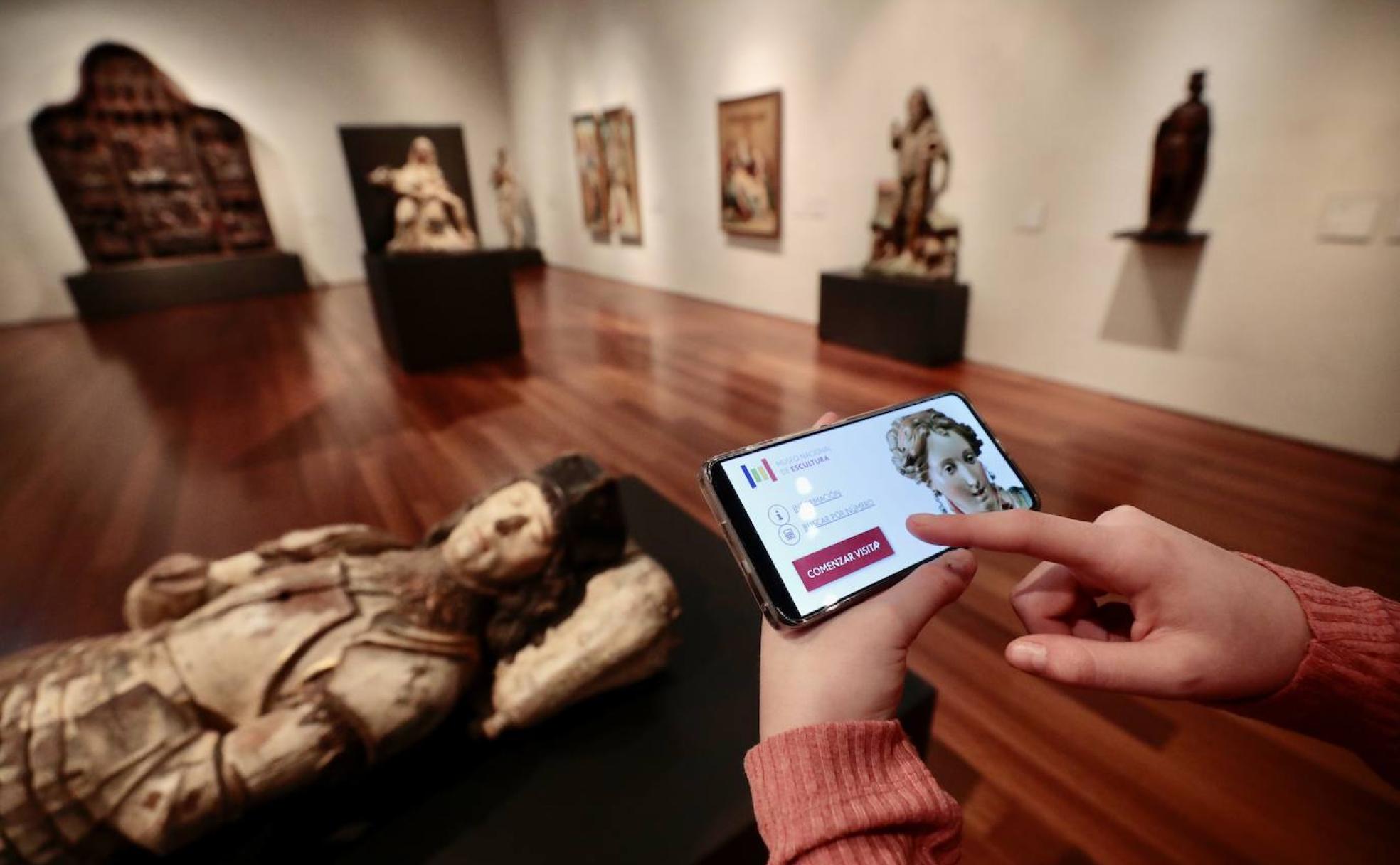 Una usuaria sigue en su aparato de telefonía la explicación sobre las tallas que se exponen en el Museo Nacional de Escultura Policromada de Valladolid.