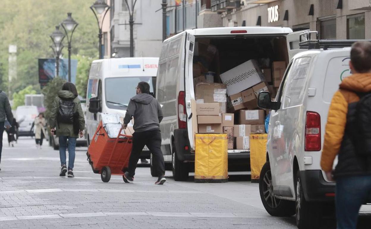 Furgonetas de reparto descargan mercancía en la calle Santiago de Valladolid.