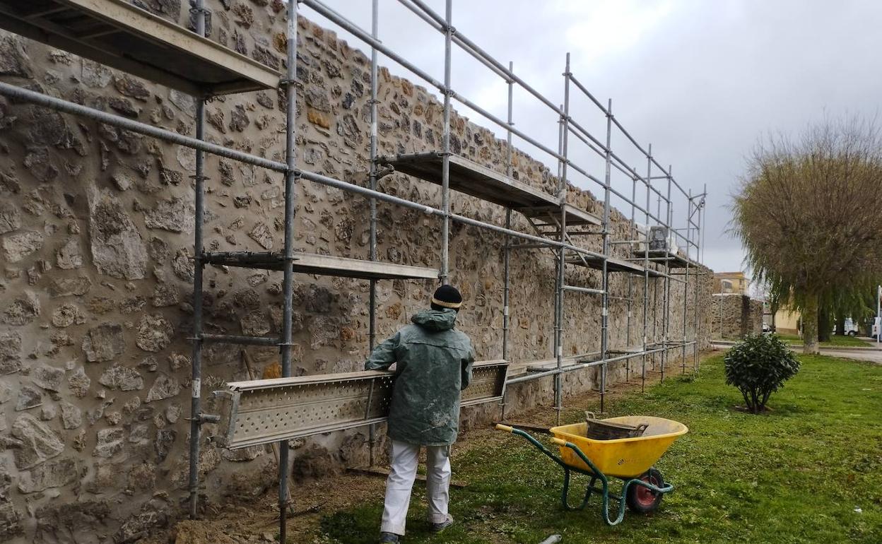 Un operario trabaja en la rehabilitación de la muralla. 