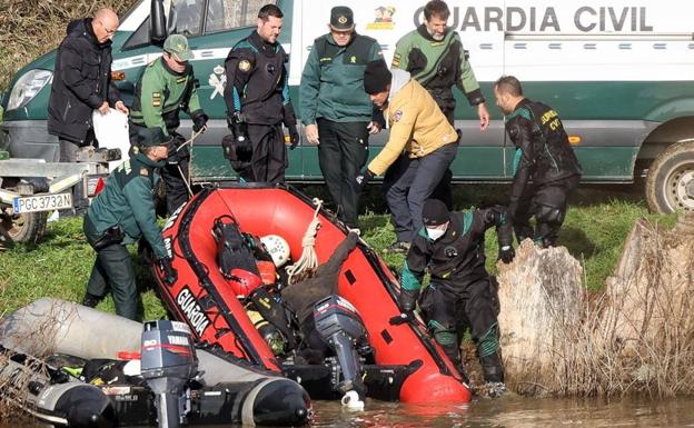 Los agentes sacan a la orilla la barca con el cuerpo de la víctima. 