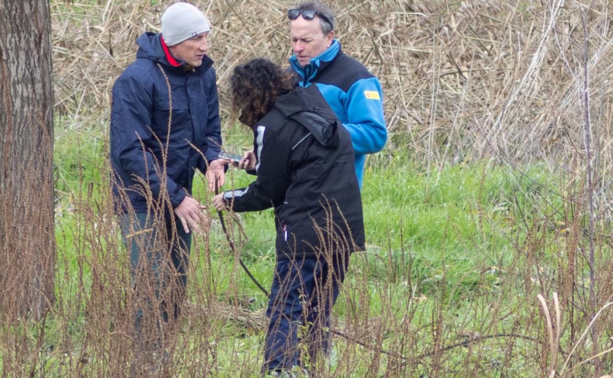 Dos miembros de la Comisión de Investigación, junto a un agente medioambiental, fotografían el cable con el que impactó el ultraligero.